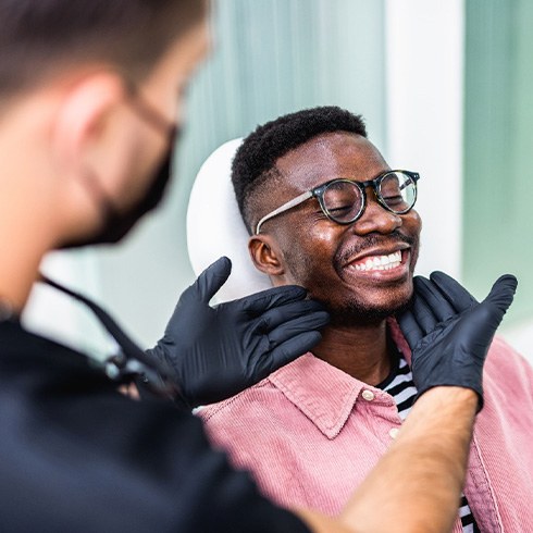Dentist looking at patient's smile in treatment room