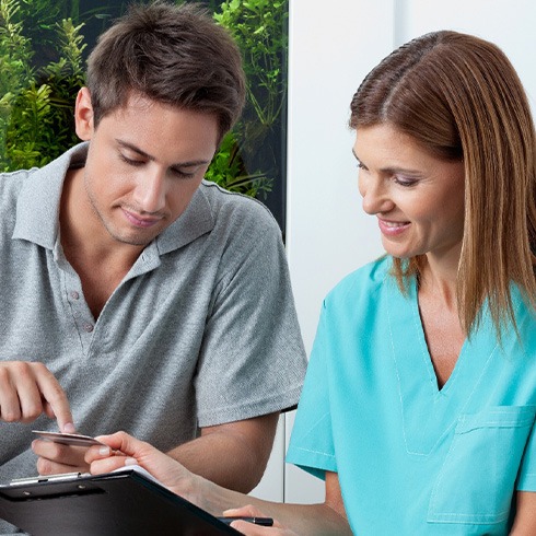 A man paying for emergency dentistry