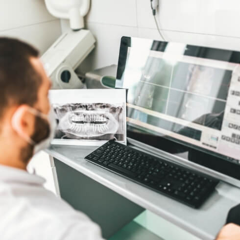 Dentist looking at digital dental x-rays