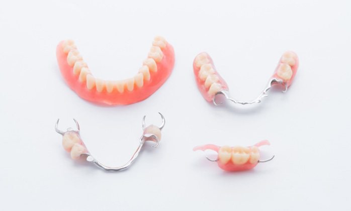 Full and partial dentures arranged against white background
