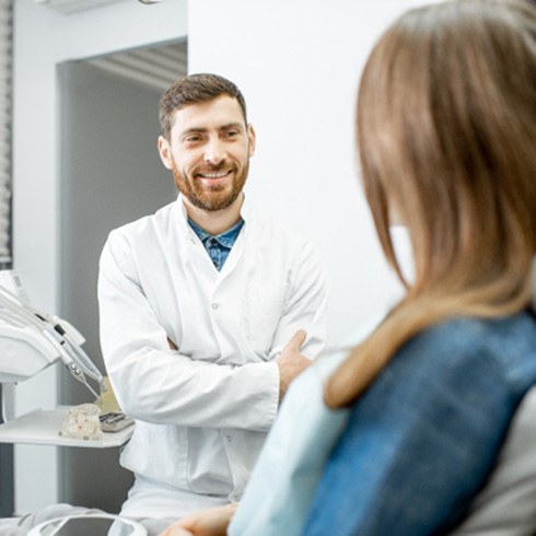 dentist smiling while talking to patients 