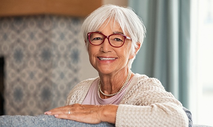 Senior woman sitting on couch and smiling
