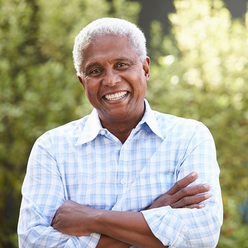 Senior man smiling with his arms folded