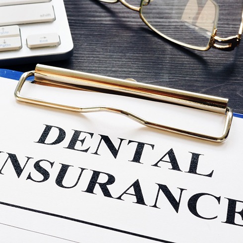 Dental insurance form on a clipboard on a desk