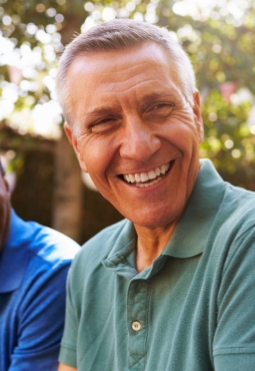 Man smiling after replacing missing teeth