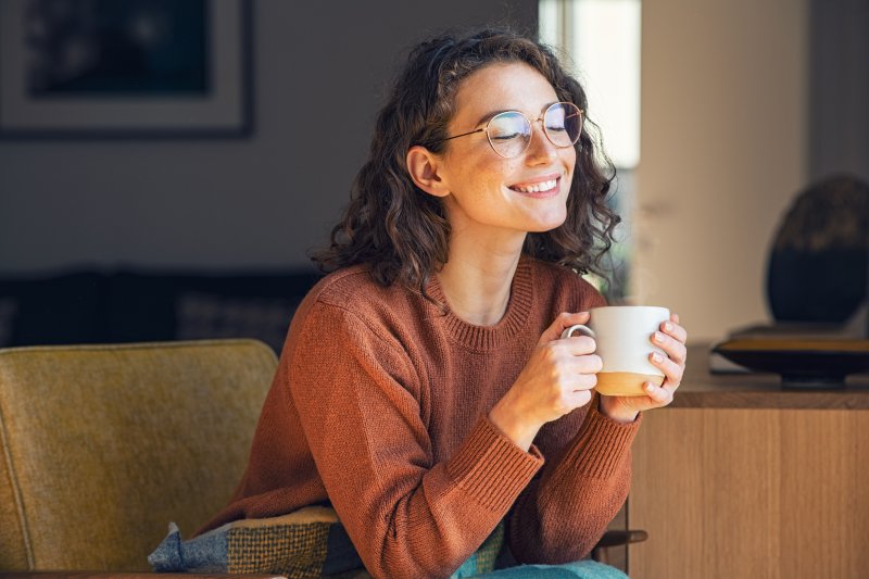 A woman enjoying her coffee two weeks after tooth extraction