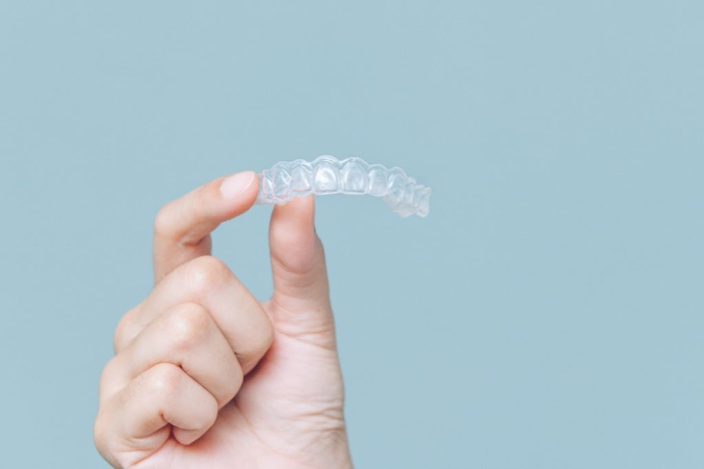 patient holding an Invisalign tray