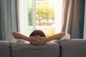 Woman resting on couch, viewed from the back