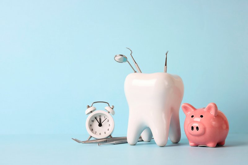 A piggy bank alongside a model of a tooth and a clock.